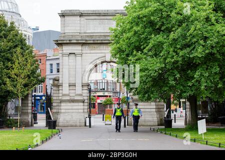 Dublin, Irland. Mai 2020. Zwei Gardai auf Patrouille zu Fuß in St. Stephen`s Green Park durch Fusiliers Arch. Covid-19 Lockdown in Dublin. Stockfoto
